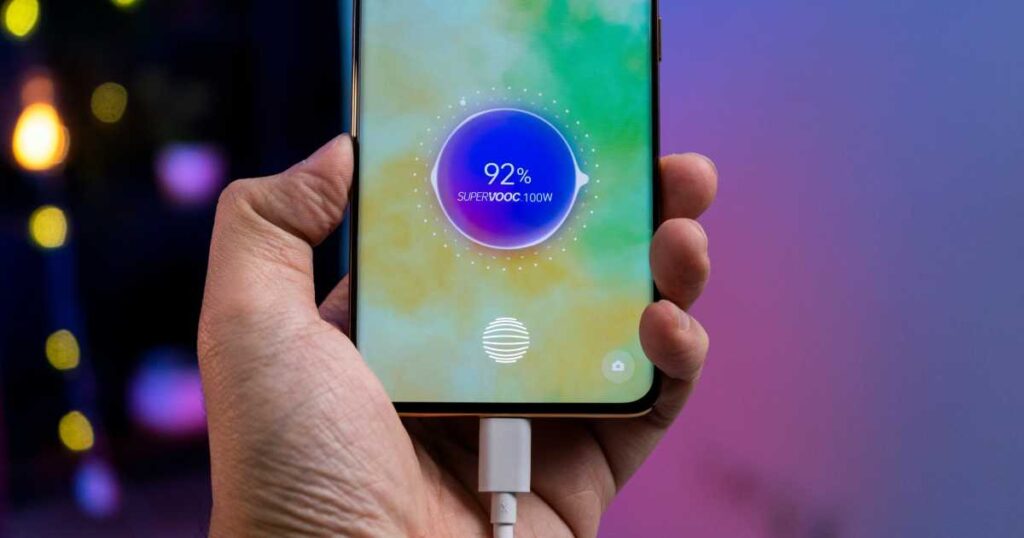 a cell phone with a charger in their hands