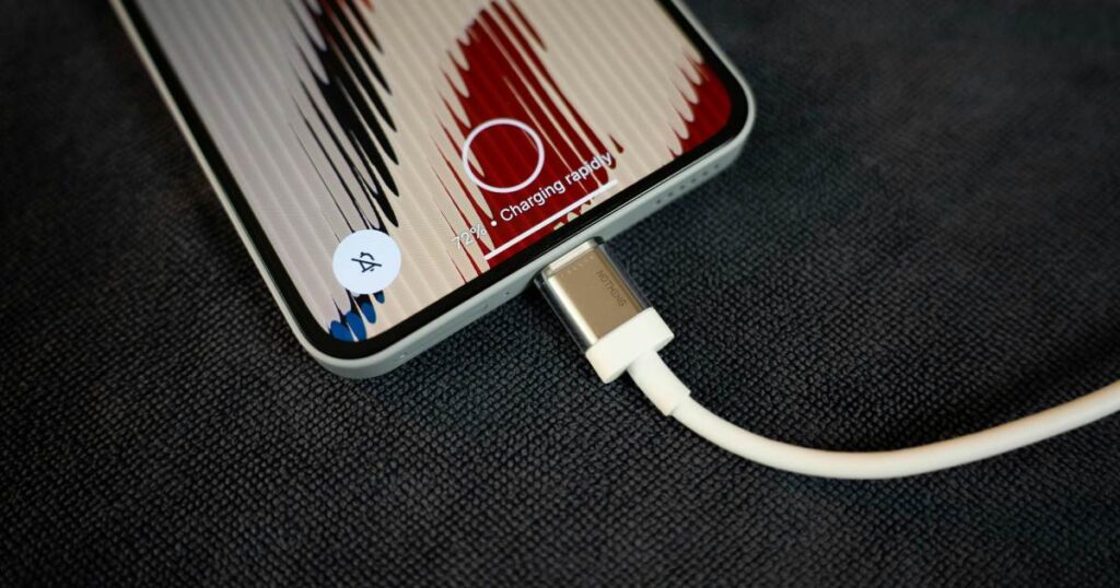 A phone is charging by its cable, charging rapidly